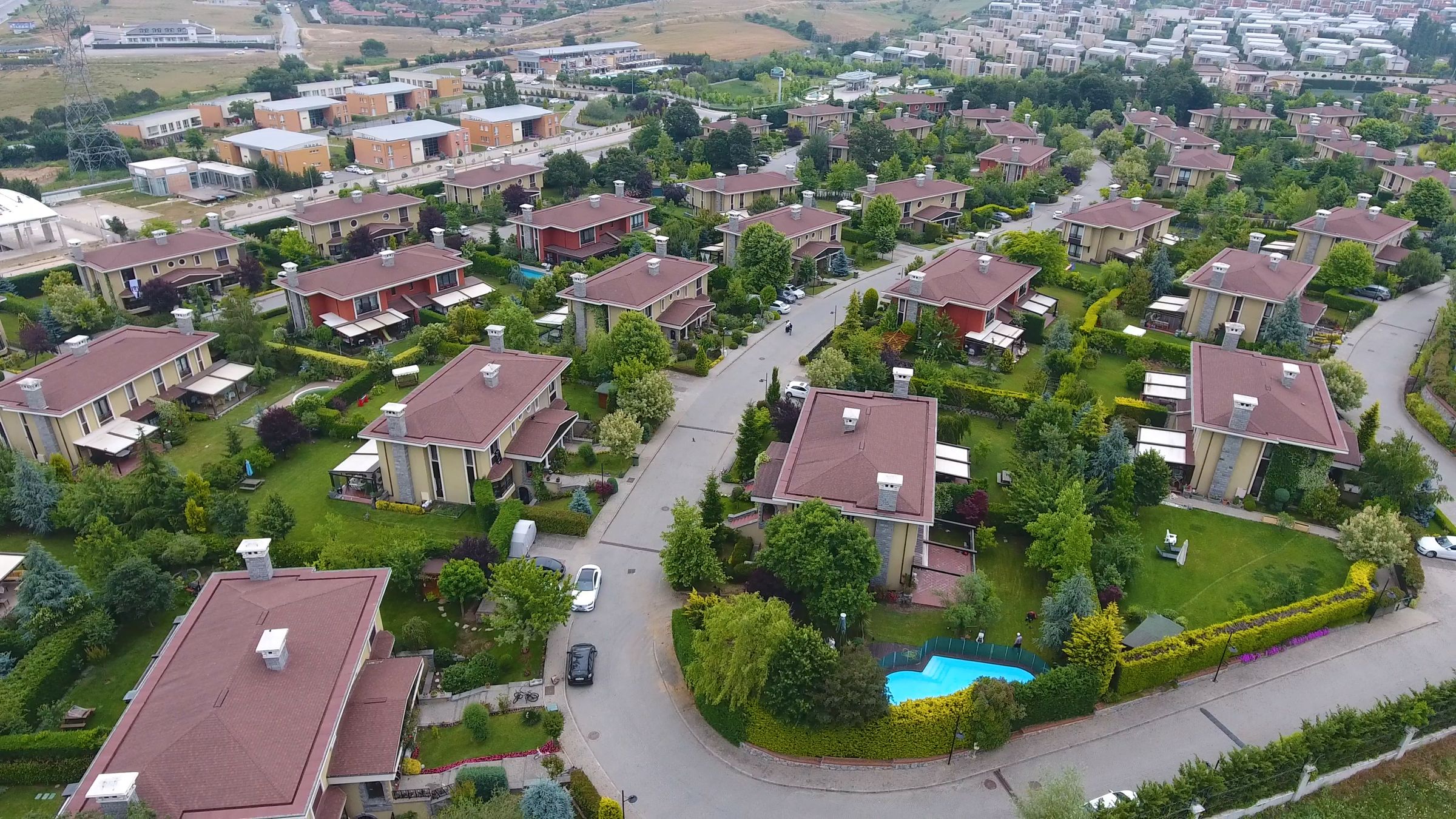 Kuğu Evleri'nin havadan görünümü: yeşil bahçeler içinde kiremit çatılı villalar